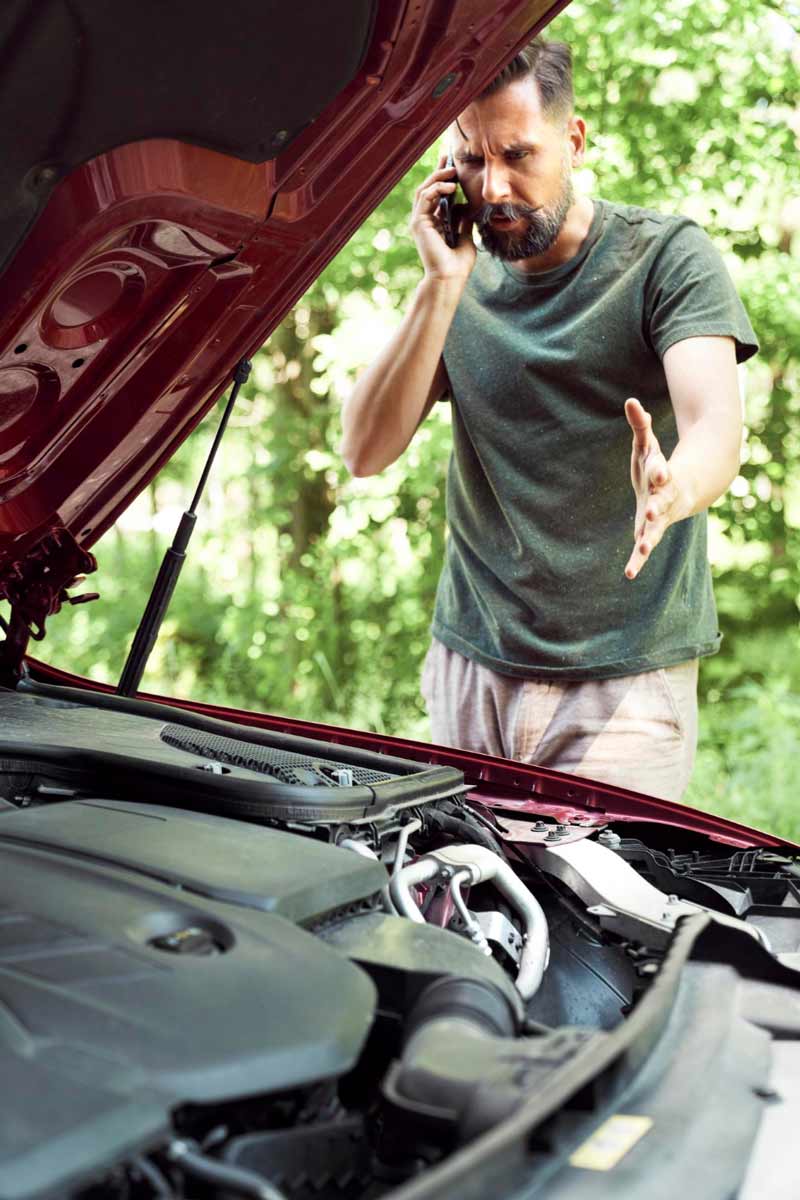 Junger Mann prüft Getriebeschaden bei Schrottauto Ankauf Dithmarschen